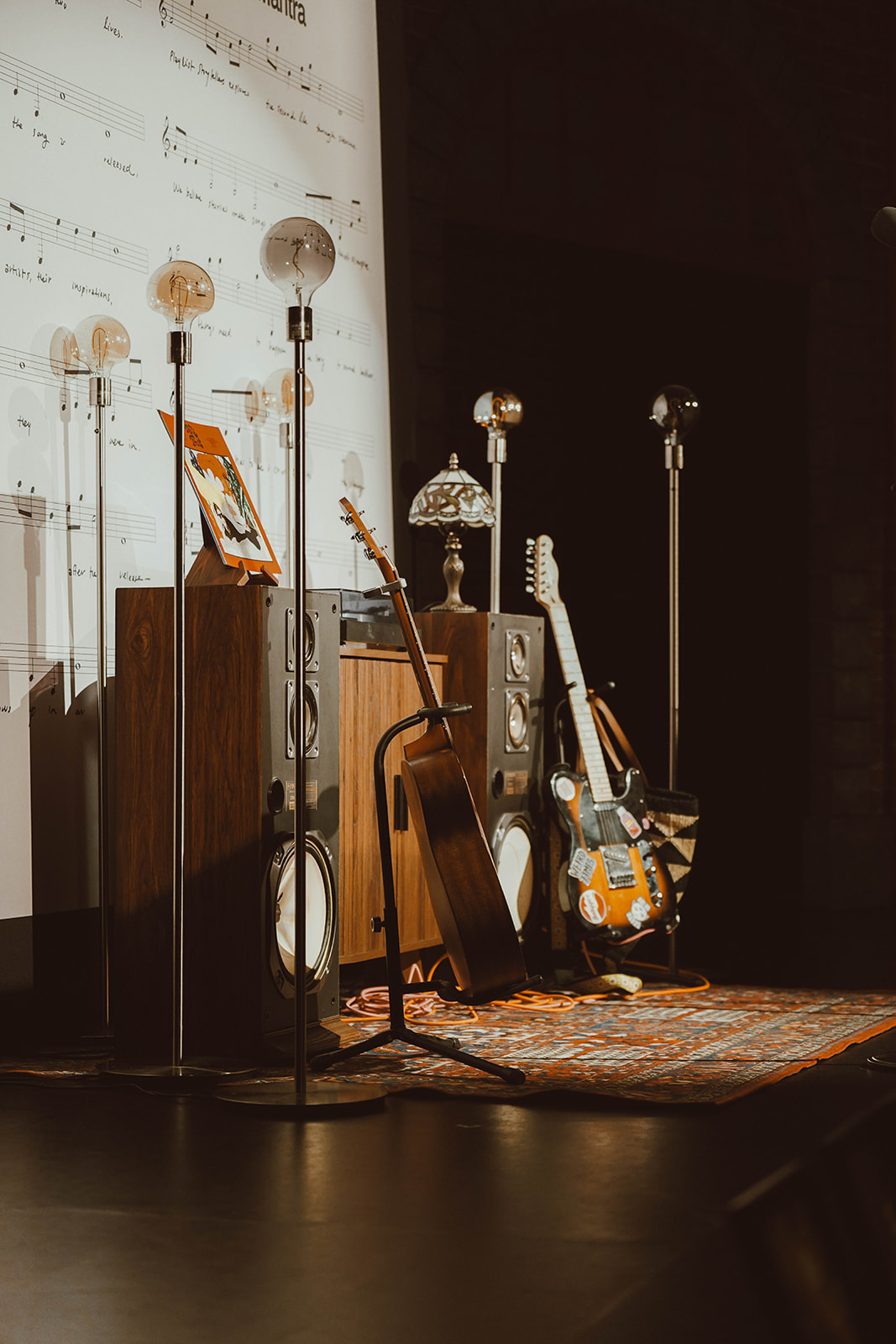 The PLST stage with bulb lamps, speakers and guitars